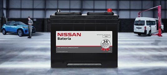 Vista completa con batería Nissan en primer plano, de fondo área de servicio Nissan Express Service.