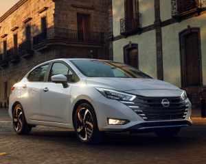 Imagen frontal de Nissan Versa gris plata blanco estacionado en la calle