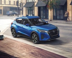 Imagen frontal de Nissan Kicks Play blanco estacionado cerca de la ciudad