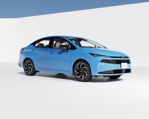 Imagen frontal de Nissan Sentra naranja estacionado cerca de la ciudad