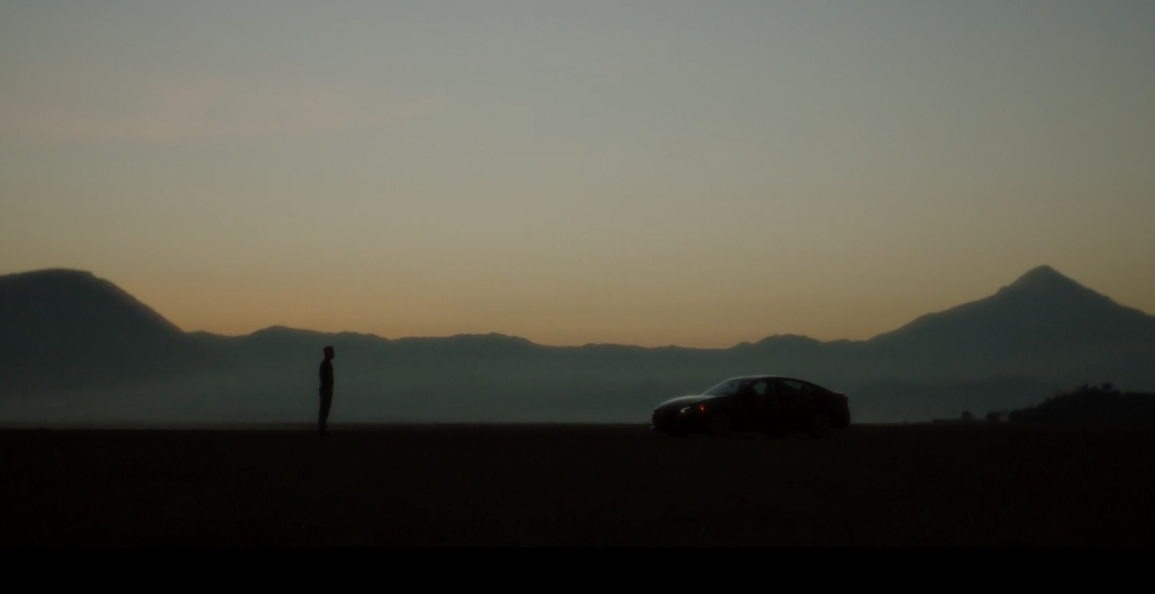 El Nissan Altima 2024 en color Rojo Burdeos se convierte en el protagonista de un atardecer en una carretera con montañas