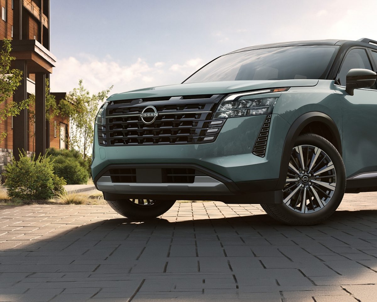 Una pareja de ejecutivos, caminan de la mano en un entorno moderno junto un imponente Nissan Pathfinder