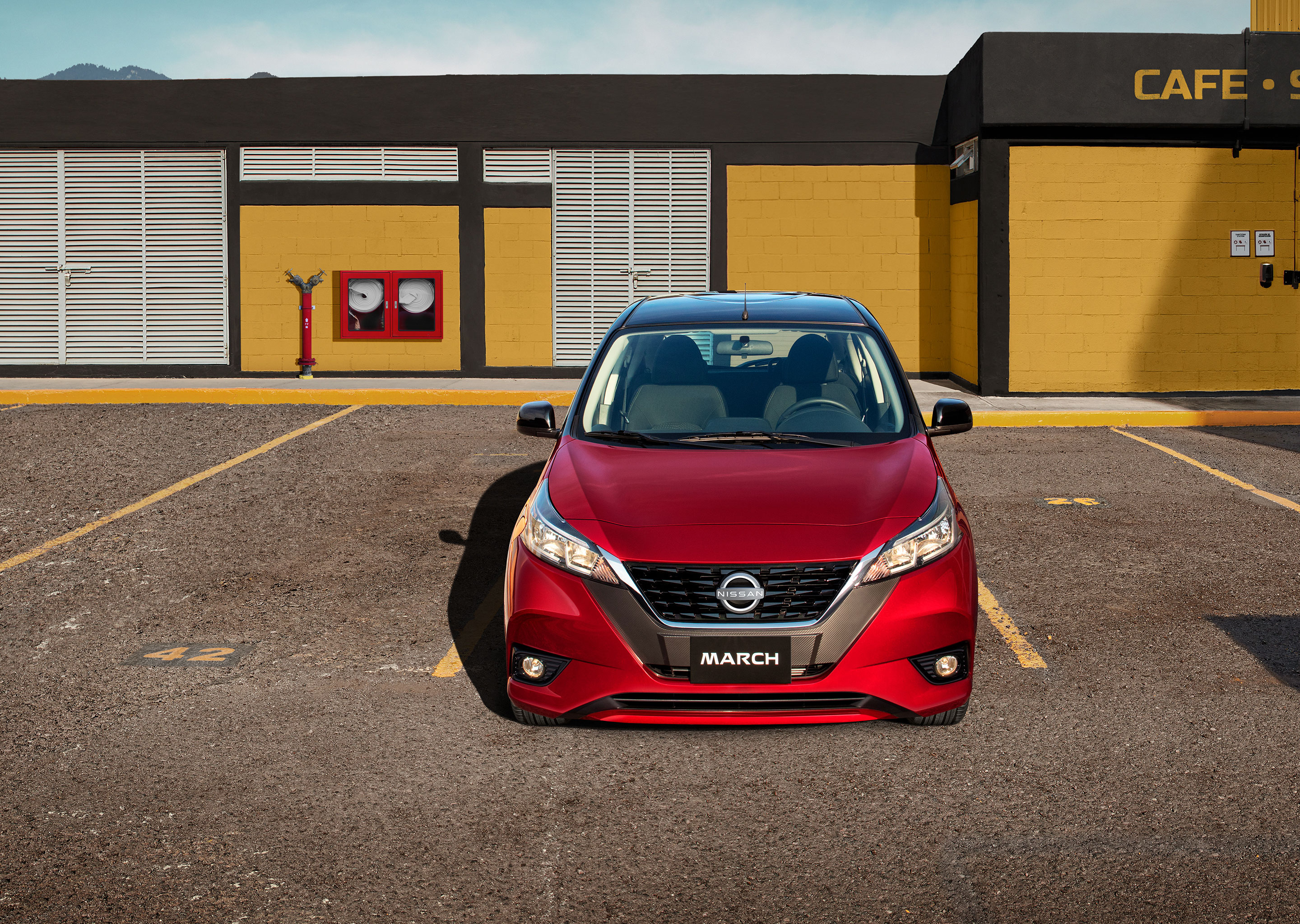 Vista frontal de Nissan March bitono con una mujer joven recargada