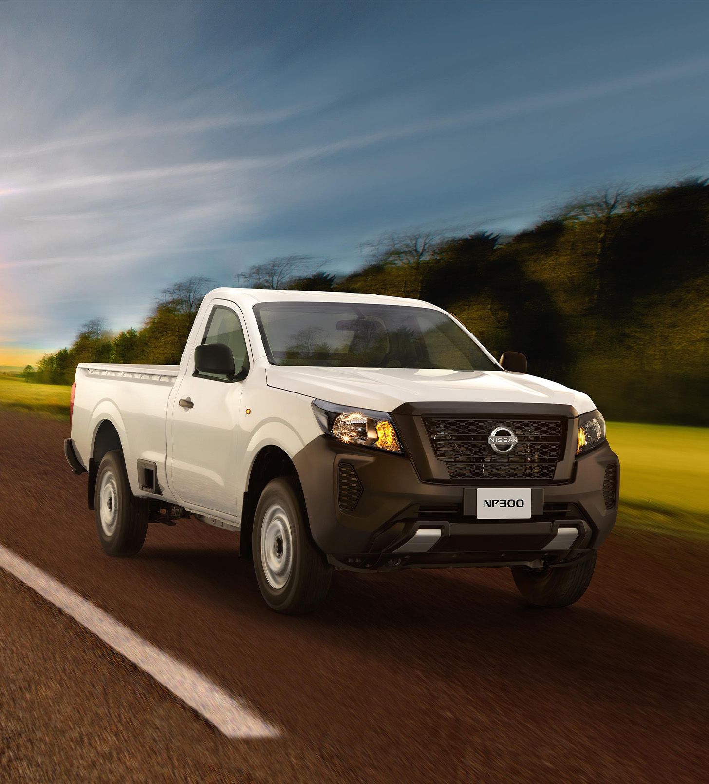 Vista tres cuartos frontal de Nissan NP300 alejándose de la puesta de sol