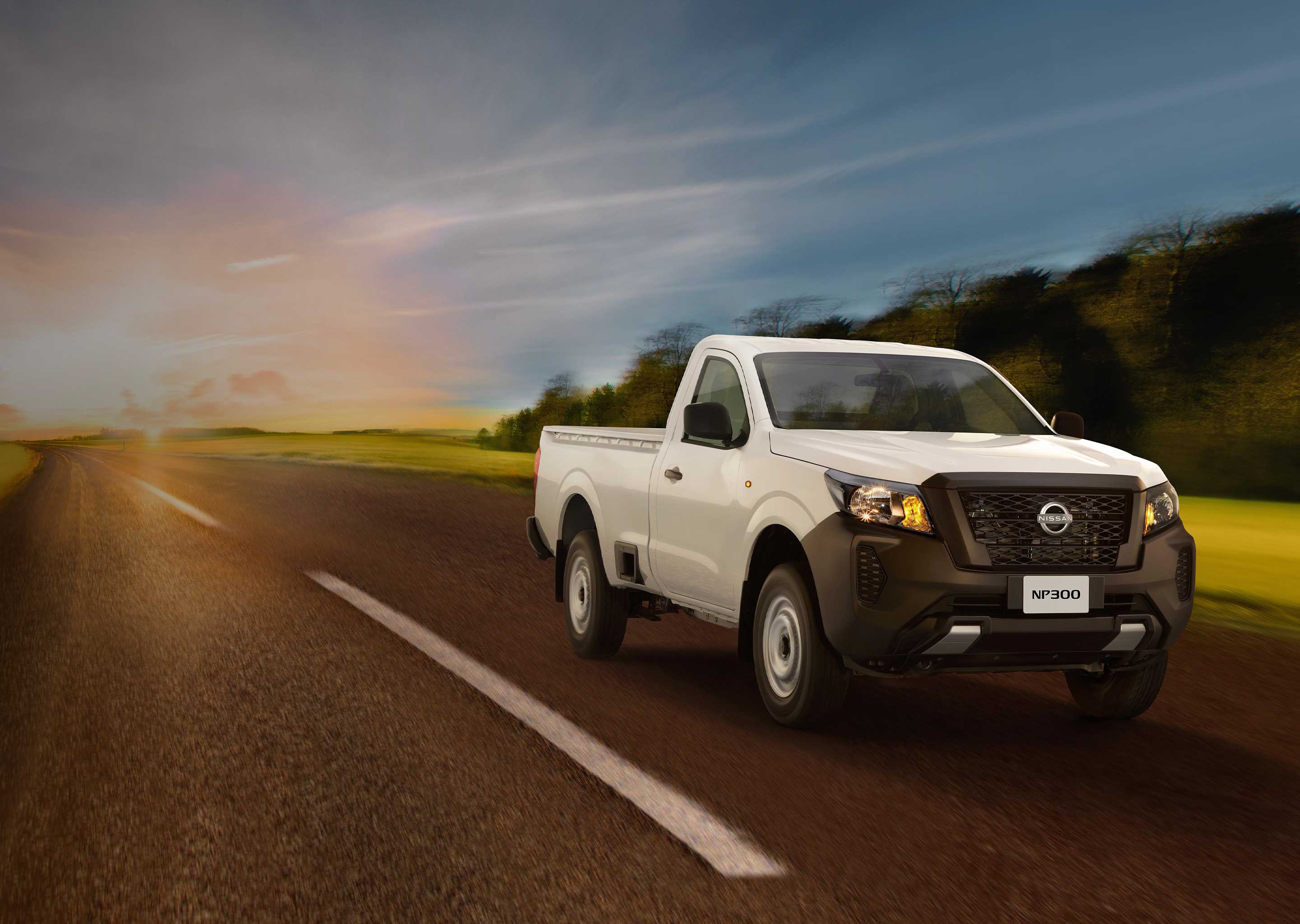 Vista tres cuartos frontal de Nissan NP300 alejándose de la puesta de sol