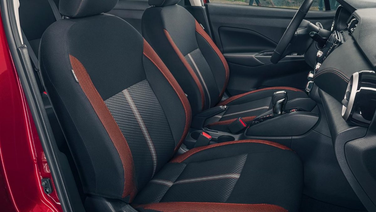 Viesta interior del Nissan Versa 2024 que deja ver los asientos en tela con detalles en color naranja