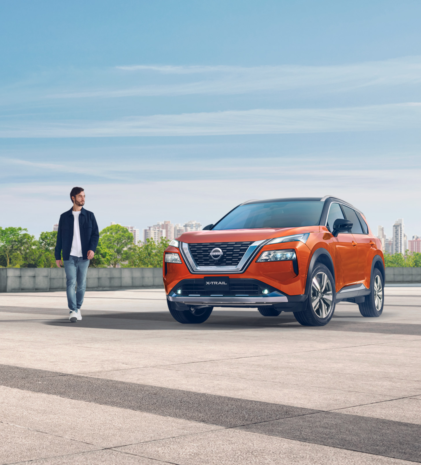  Vista frontal tres cuartos en formato vertical de Nissan X-Trail con hombre caminando.