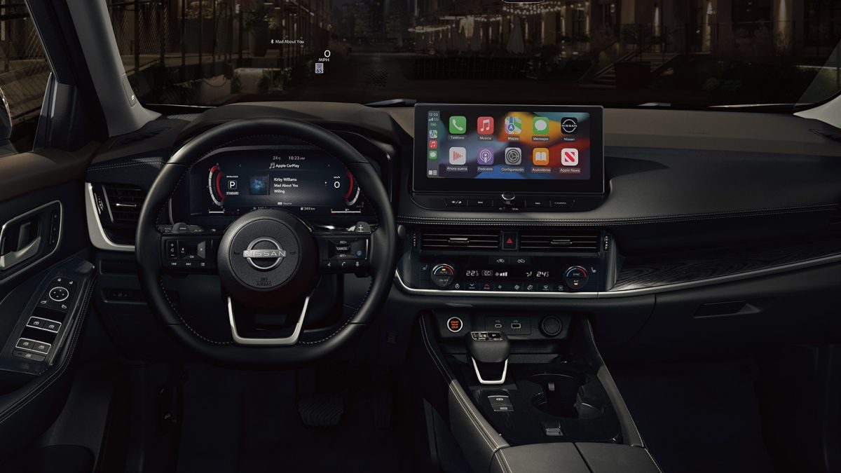 Detalle interior frontal de Nissan X-Trail 2026 con palanca de cambios e interiores premium.