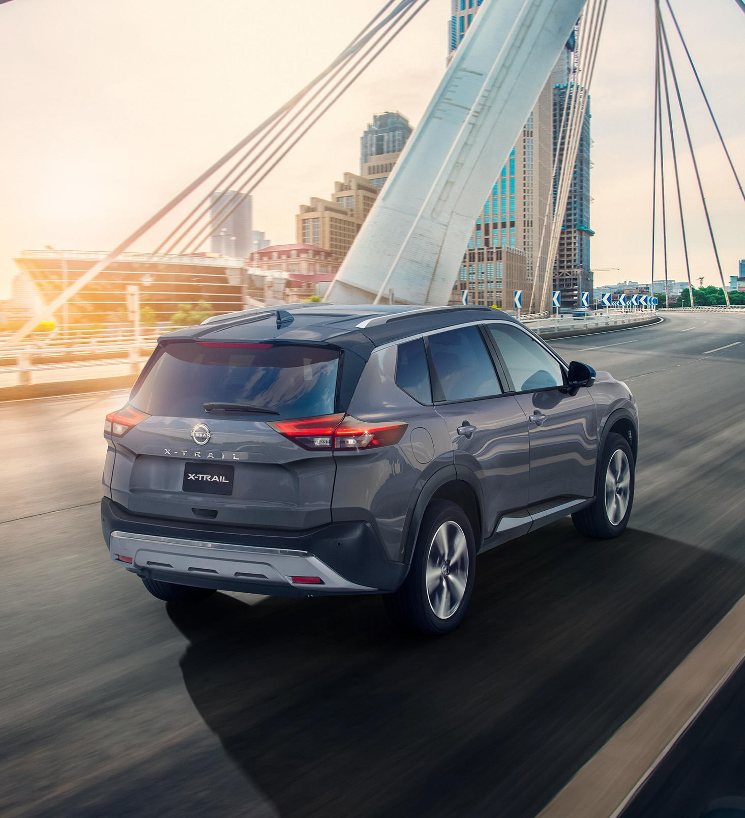 SUV de Nissan, X-Trail 2026 color gris en carretera al atardecer
