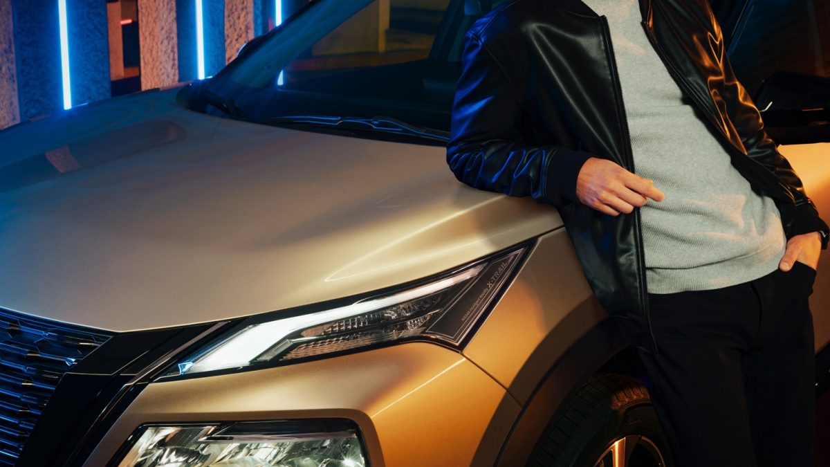 Detalle de faros de Nissan X-Trail e-POWER color champagne con hombre al costado con Signature Lamps con todo el poder electrizante.