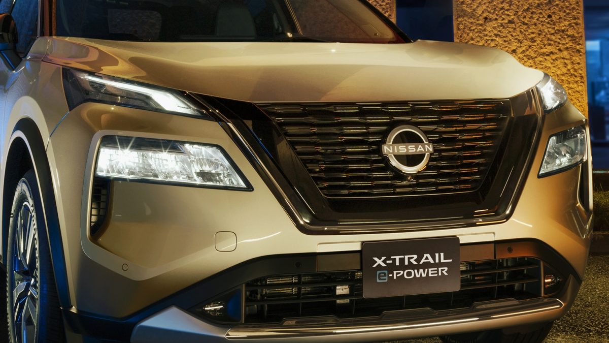 Vista frontal de la parrilla V motion de Nissan X-Trail e-POWER 2026 con hombre abriendo puerta delantera. Con Faros LED con ajuste manual, encendido y apagado automático y Signature Lamps.