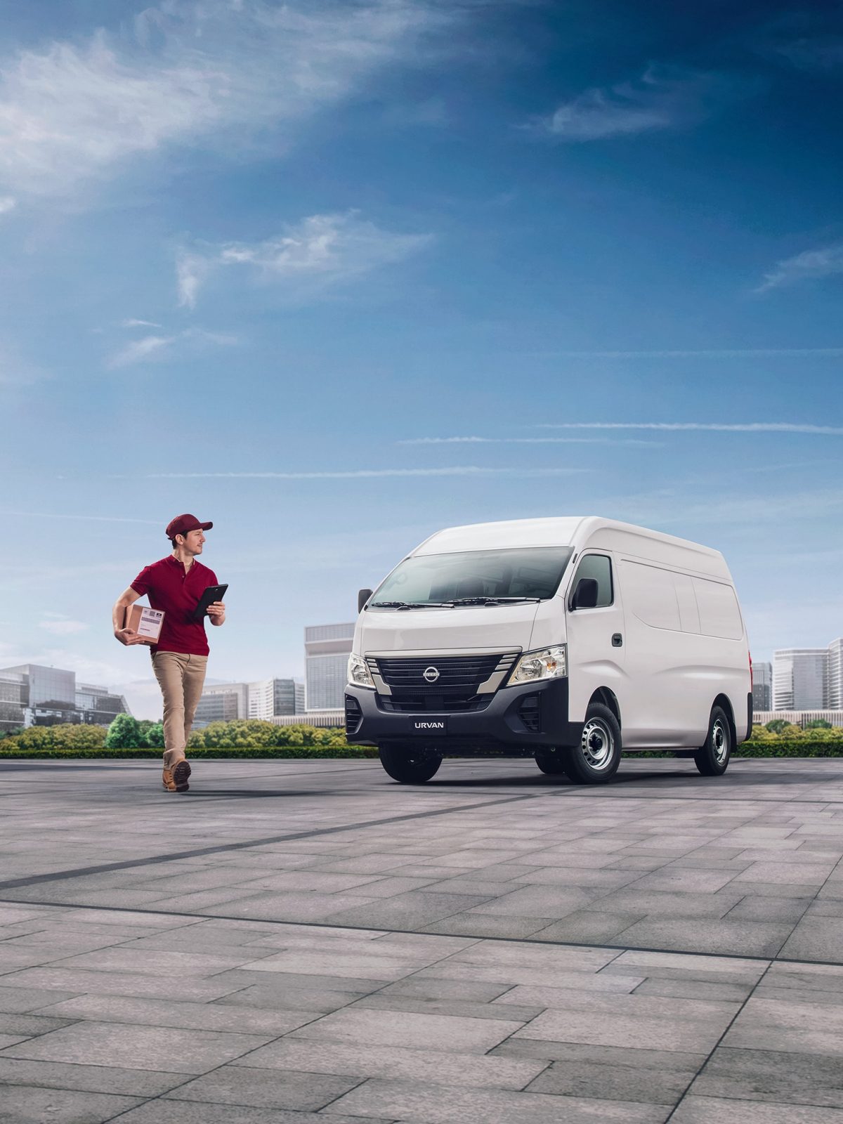 Un hombre con un paquete en una Nissan Urvan de pasajeros estacionada