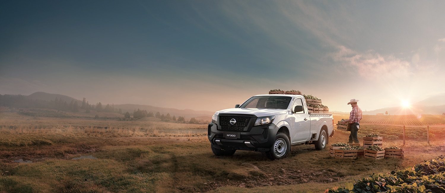 Un hombre de campo carga su Nissan NP300 con la cosecha que ha cultivado en un bello atardecer