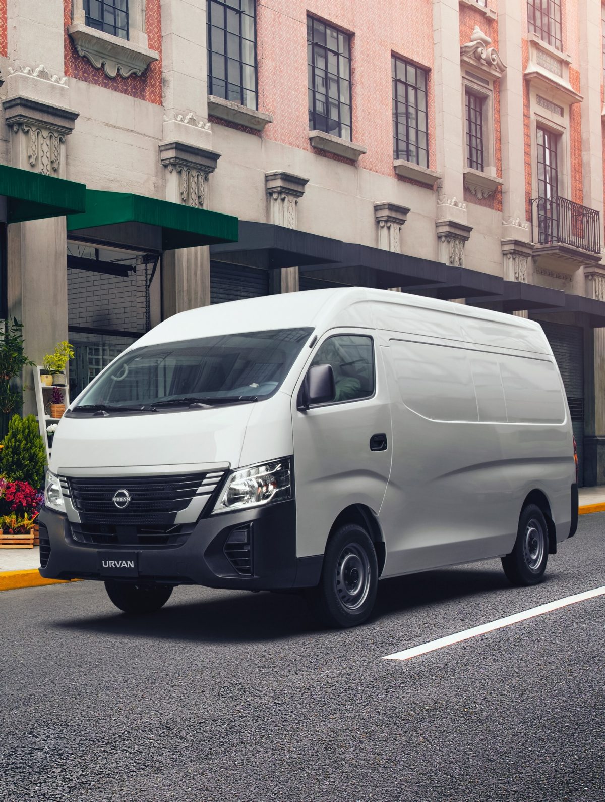Una Nissan Urvan está frente a una florería, la encargada se dispone a colocar su mercancía en ella
