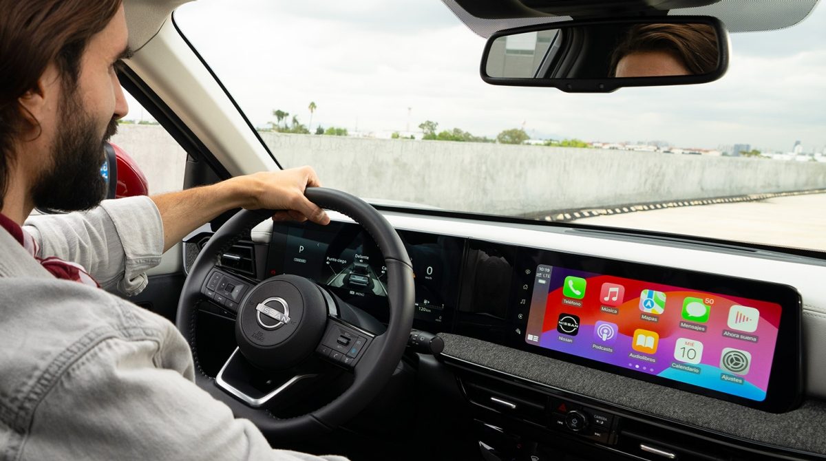 Hombre manejando feliz su Nissan con las tecnologías de NissanConnect Services